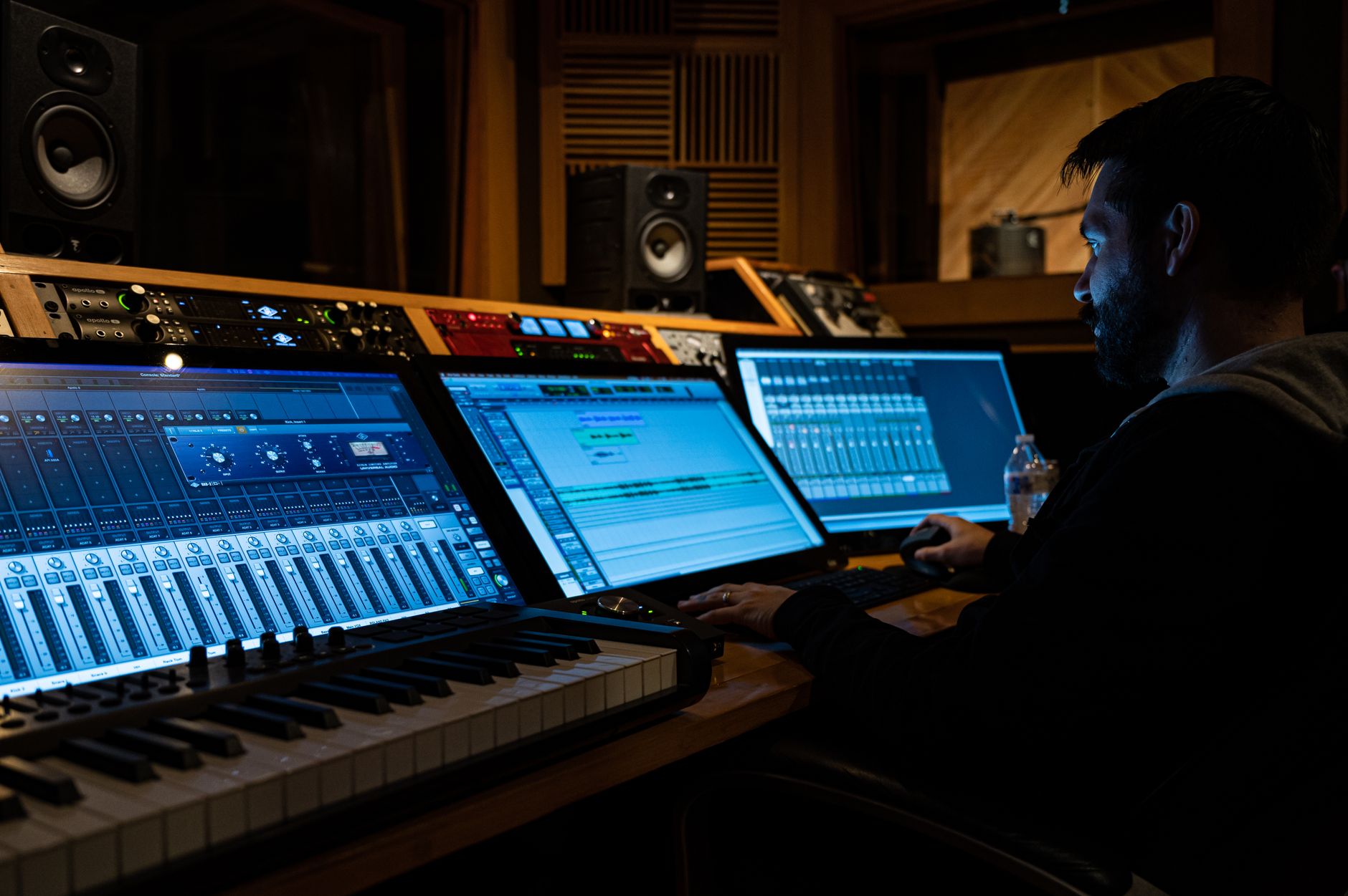 Side view of music producer working at computer in studio