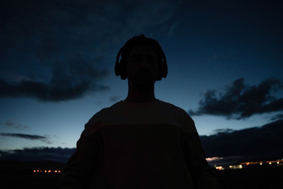 Silhouette of a person wearing headphones at dusk