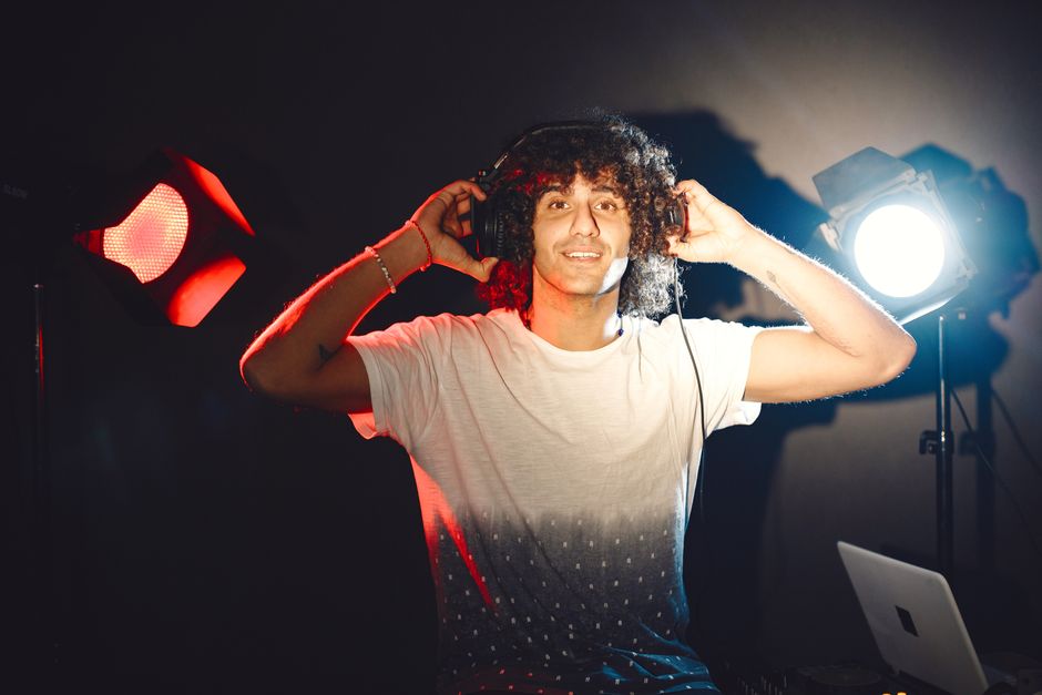 Producer wearing headphones during a music production session