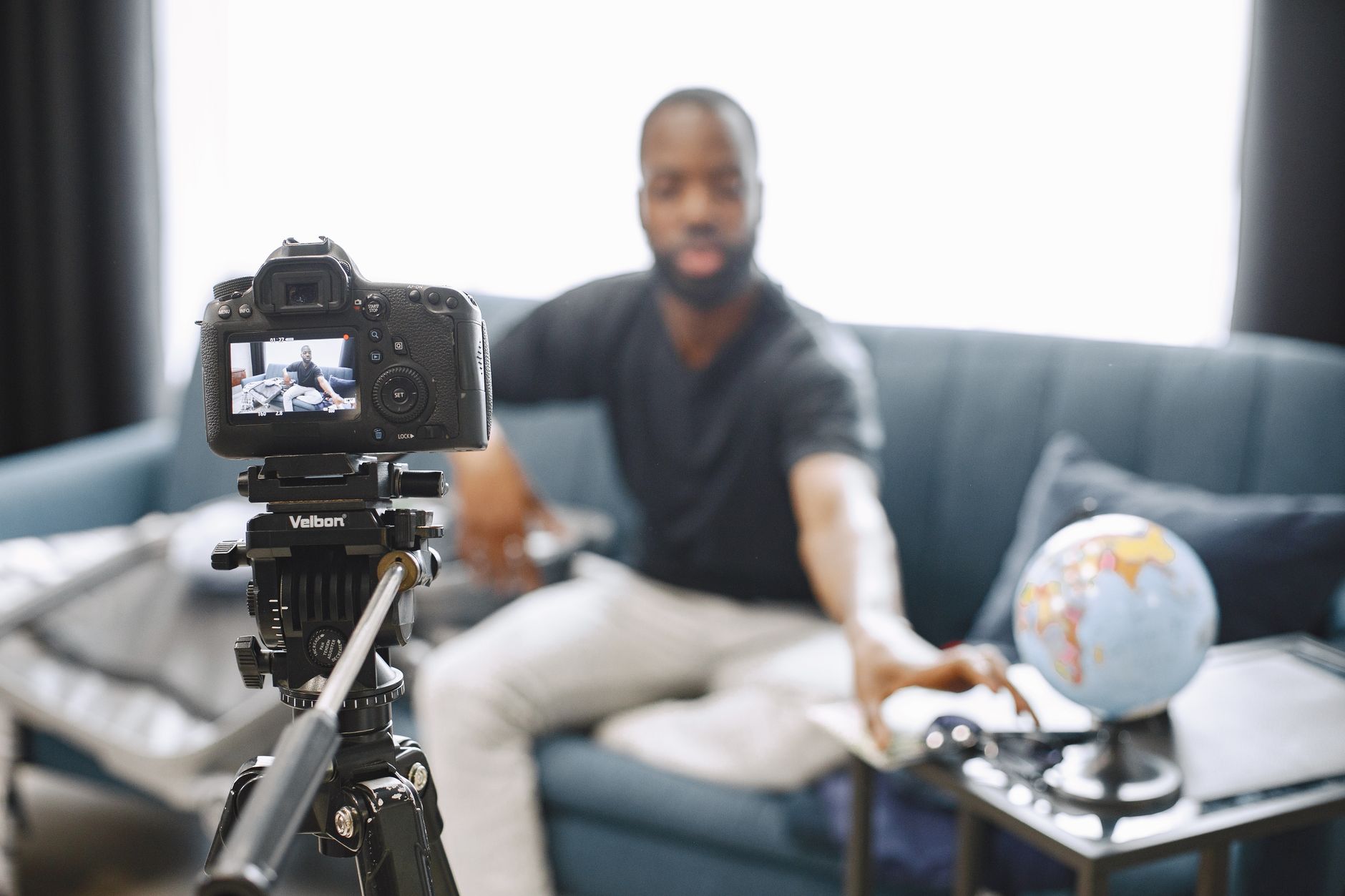 Content creator adjusting a camera on a tripod to film indoors