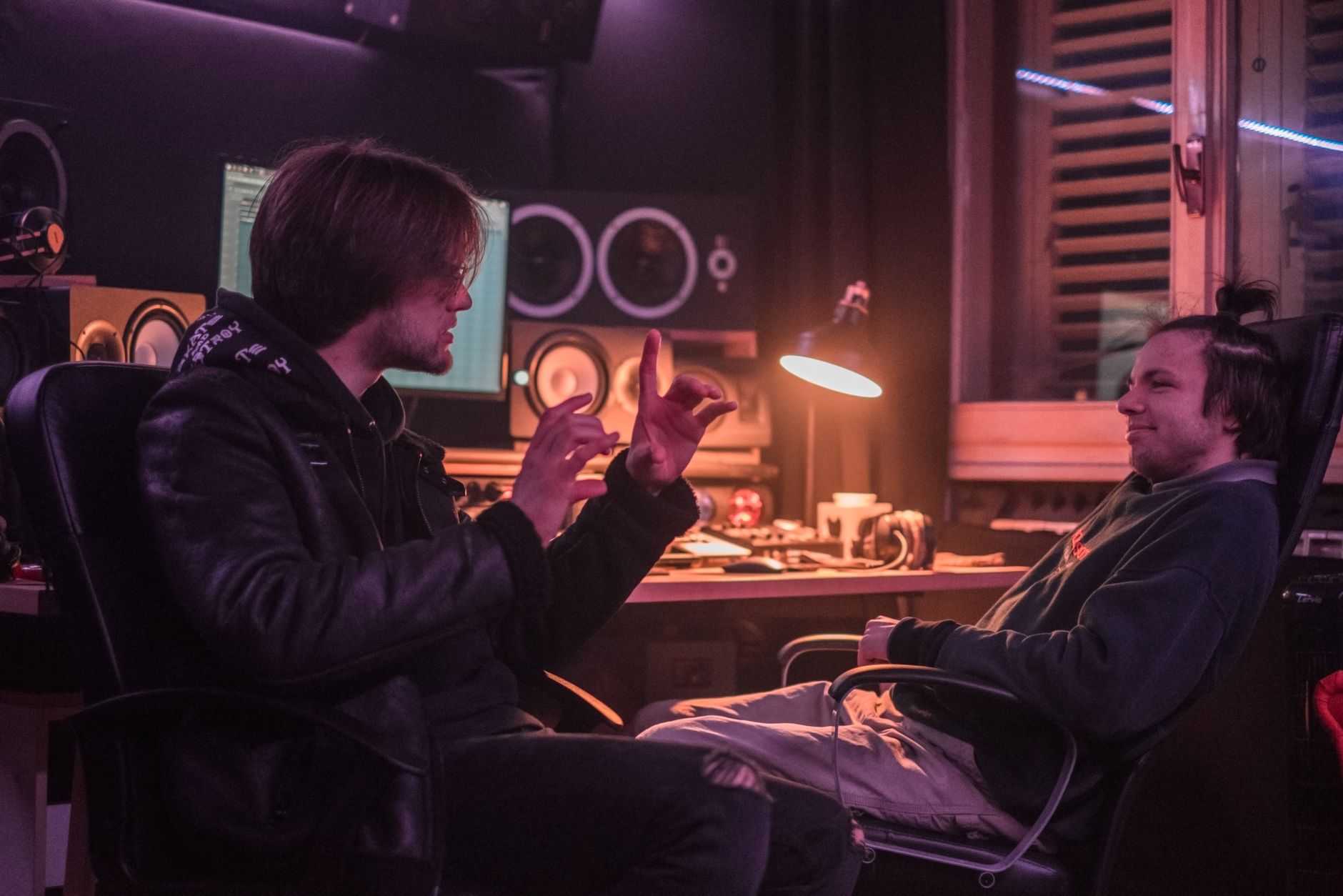 Two producers in a focused music discussion in a home studio