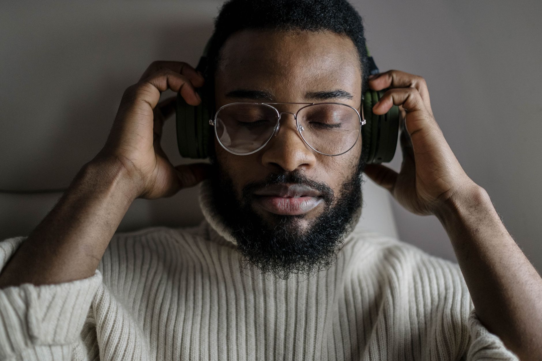Person listening closely to music through headphones